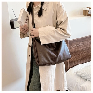 Detail of soft dark brown PU leather shoulder bag with vintage pleated texture for women