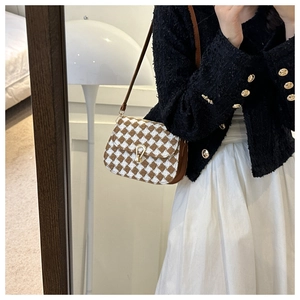 Detail of checkered woolen saddle bag with gold buckle and brown leather strap