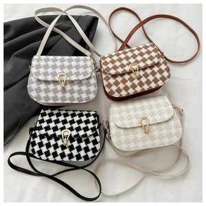 Detailed top view of four tweed plaid saddle bags with golden metal clasps and straps