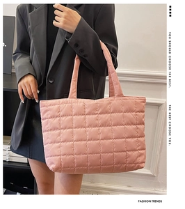 Detail of pink quilted tote bag with square stitching and thick reinforced handles