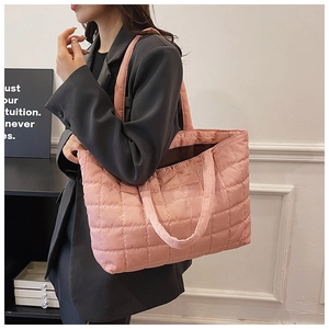 Detailed view of pink quilted tote bag with diamond stitching and wide shoulder straps