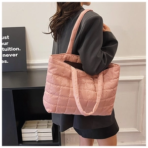 Close-up of pink quilted tote bag with shiny water-resistant nylon texture on shoulder
