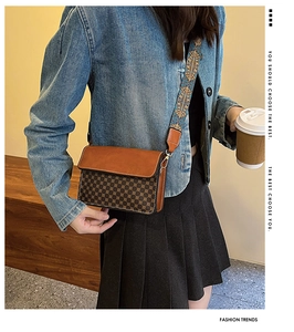 Detail of vintage patterned crossbody bag featuring a wide geometric ethnic shoulder strap