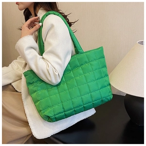 Close-up of vibrant green quilted tote bag with checkerboard stitching and soft straps