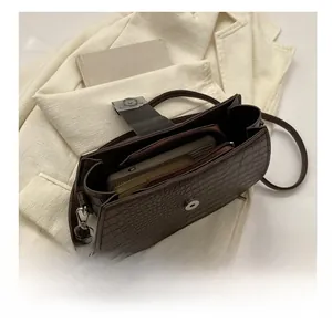 Detailansicht der offenen dunkelbraunen Kroko-Handtasche mit Fokus auf das Innenfach