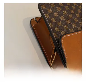 Detailed macro shot of the golden metal hook and vintage floral pattern on a crossbody bag