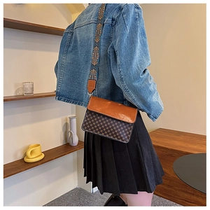 Retro monogram crossbody bag with colorful ethnic wide strap shown on model's shoulder