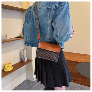 Detail of vintage square crossbody bag featuring classic patterns and embroidered wide strap
