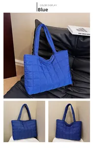 Gedetailleerde weergave van blauwe gewatteerde tote bag met ruitstiksel en zachte textuur