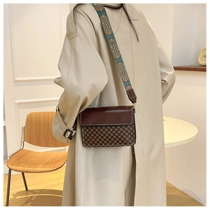 Detail of vintage patterned crossbody bag with wide bohemian woven shoulder strap for women