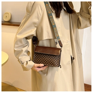 Detail of vintage crossbody bag with geometric pattern and embroidered wide shoulder strap