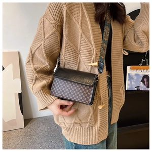 Close-up of vintage crossbody bag with patterned body and ethnic wide shoulder strap