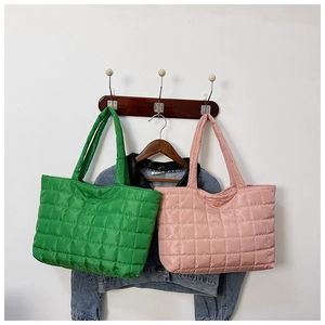 Detailed view of green and pink quilted tote bags made of padded nylon material