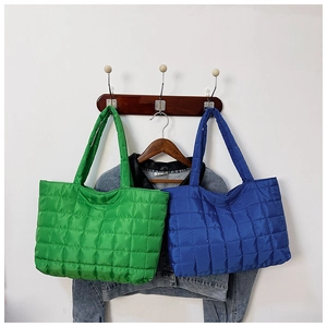 Detail view of large quilted tote bags in vibrant green and blue colors