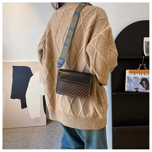 Detail of vintage patterned crossbody bag with chic embroidered wide shoulder strap