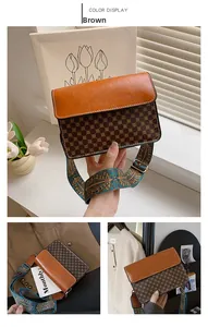 Close-up of vintage brown crossbody bag featuring embroidery wide strap and gold hardware
