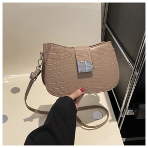 Detail der khakifarbenen Handtasche mit Krokodilmuster und silberner Metallschnalle