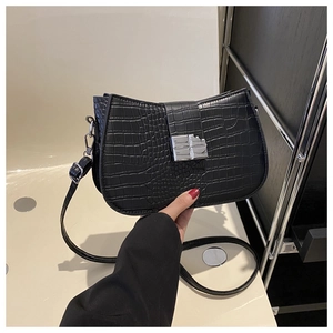 Details der schwarzen Schultertasche mit Krokodilprägung und rechteckigem Silberverschluss
