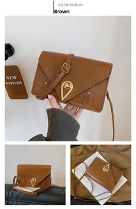 Detail view of brown retro flap crossbody bag with golden teardrop turn-lock closure