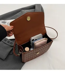 Binnenaanzicht van de bruine gewatteerde crossbodytas met ruime inhoud voor mobiele telefoon