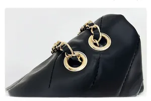 Vue détaillée du cuir matelassé noir avec bandoulière en chaîne dorée et œillets en métal