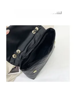 Vue intérieure montrant les compartiments spacieux et la poche zippée du sac matelassé en PU
