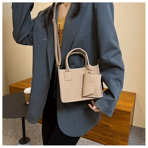 Detail view of beige felt tote bag set with geometric embossed patterns and shoulder strap