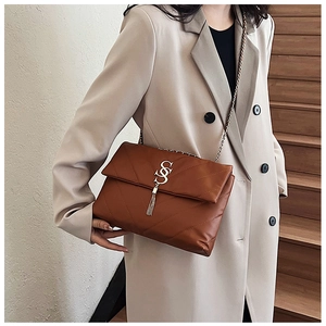 Sac bandoulière marron matelassé en similicuir avec bandoulière chaîne et gland sur modèle