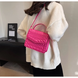 Fuchsia gewatteerde handtas met schouderriem getoond op model in moderne setting