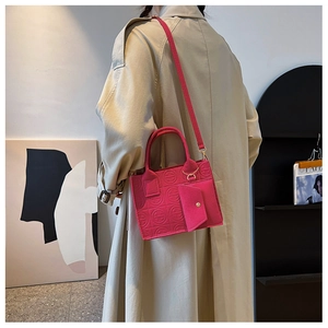 Detail of rose pink felt handbag with circular texture and detachable crossbody strap