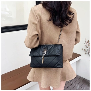 Détail du sac bandoulière noir matelassé avec surpiqûres en V et glands métalliques chic