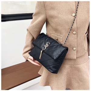 Détails du sac à bandoulière en cuir matelassé noir avec coutures en V et pompons dorés