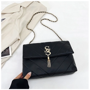 Détail du sac à bandoulière en similicuir noir matelassé avec pompon doré et logo SS