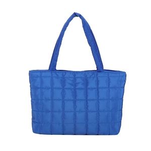Navy blue quilted puffer tote bag with padded handles in a minimalist rectangular design