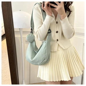 Detail of light green crescent nylon bag with adjustable strap and coin purse
