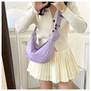 Light purple crescent nylon bag shown on model with adjustable wide strap and round coin pouch