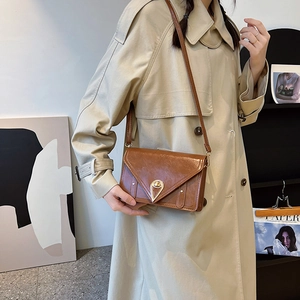 Brown vintage faux leather crossbody bag with golden triangular lock and sleek flap design