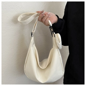 Detail of a beige nylon hobo bag with a wide strap and a matching mini round coin purse