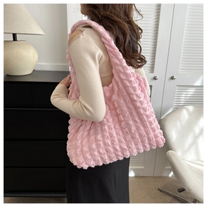 Détail du tissu à texture bulle rose sur un grand sac à bandoulière léger pour femme