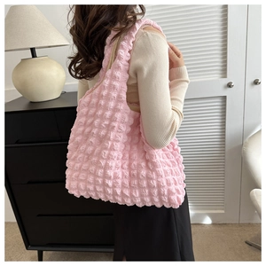 Détail de la texture gaufrée rose sur un sac à bandoulière léger et minimaliste