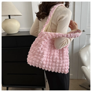 Gros plan du sac rose à texture bulle et détails plissés dans un décor intérieur élégant