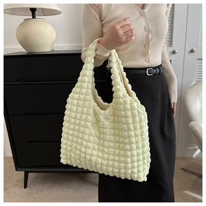Détail du tissu texturé à bulles crème sur ce sac à main léger pour femmes
