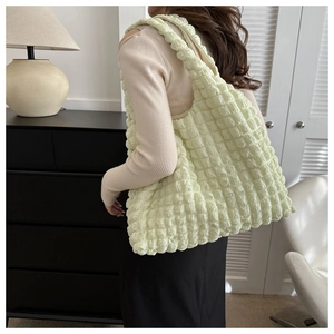 Détail de la texture gaufrée vert clair sur un grand sac à bandoulière pour femme