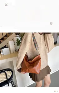 Detail of vintage brown PU leather shoulder bag with a colorful geometric strap