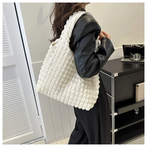 Détail d'un sac cabas à texture bulles blanc crème porté à l'épaule pour femme