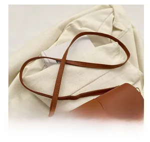 Detail of blue geometric fabric stitching and brown leather flap with gold metal buckle
