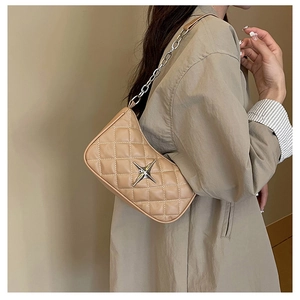 Close-up of quilted leather crossbody bag with silver star emblem and chain strap