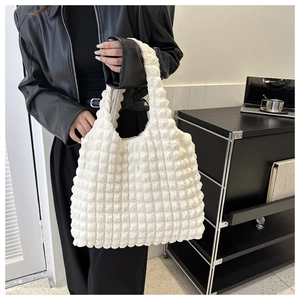 Détail de la texture en tissu gaufré blanc sur un sac à main plissé pour femme