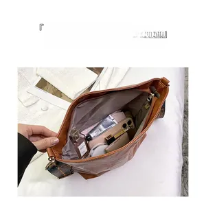 Spacious interior of vintage brown tote bag with daily items and patterned strap