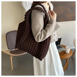 Vue détaillée du sac cabas marron café à texture bulle porté par un mannequin